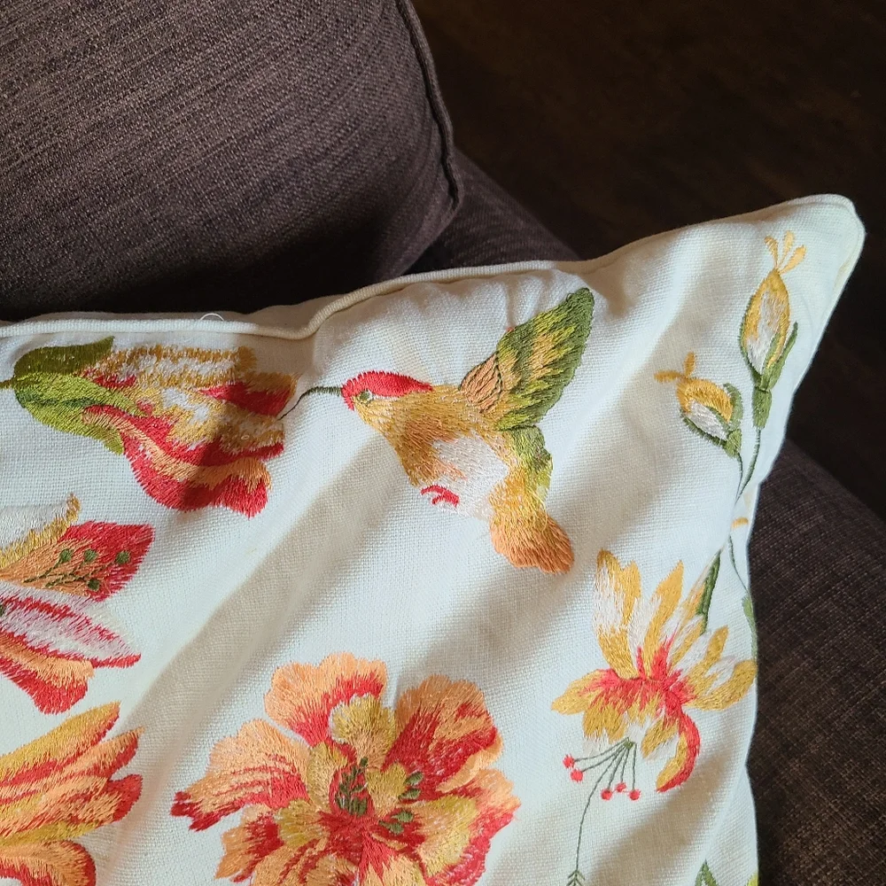 2 pillows with embroidered flowers and hummingbirds